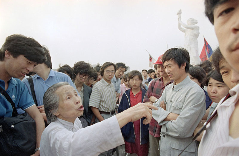 Жительница Пекина дискутирует со студентами о принципах демократии. На заднем плане возвышается монумент «Богиня демократии». 31 мая 1989 года, площадь Тяньаньмэнь, Пекин. Фото: Jeff Widener / AP Photo