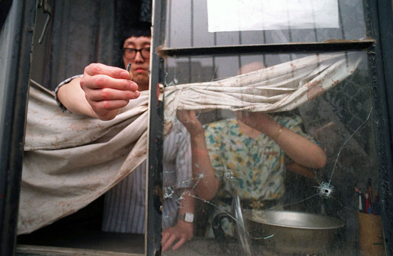 Житель Пекина демонстрирует следы от пуль автоматического оружия, которое применяла армия во время разгона студентов. 1989. Фото: Manuel Ceneta / AFP / Getty Images